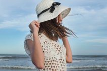 Девочка-подросток стоит на пляже, держа шляпу, Аргентина — стоковое фото