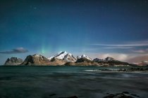 Northern lights brewing over Mt. Himmeltinden, Lofoten, Nordland, Norway — Stock Photo