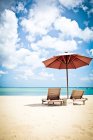 Deux chaises longues et un parasol sur la plage, Jimbaran Beach, Bali. Indonésie — Photo de stock