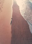 Повітряний вид людини з серфом йде уздовж тринадцятого пляжу (Вікторія, Австралія). — стокове фото