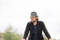 Retrato de un hombre de pie al aire libre apoyado en una pared - foto de stock