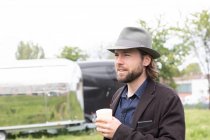 Портрет чоловіка, що стоїть на відкритому повітрі, тримає чашку кави — стокове фото