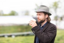 Портрет чоловіка, що стоїть на відкритому повітрі, п'є чашку кави — стокове фото