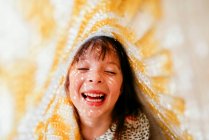 Ragazza ridente con lentiggini ricoperte di tessuto e raggi di sole sul viso — Foto stock
