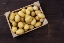 Blick über den Kopf auf eine Kiste mit frischen Kartoffeln — Stockfoto