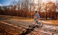 Chica montando una bicicleta en el parque, Estados Unidos - foto de stock