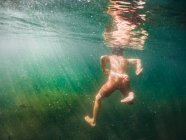 Menino nadando debaixo d 'água em um lago, Estados Unidos — Fotografia de Stock