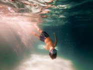 Мальчик ныряет в бассейн — стоковое фото