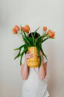 Retrato de uma menina segurando um vaso de tulipas — Fotografia de Stock