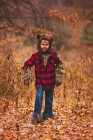 Retrato de un niño de pie en el bosque vestido de hombre lobo para Halloween, Estados Unidos - foto de stock