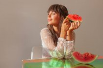 Улыбающаяся женщина держит кусок арбуза — стоковое фото