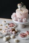 Gâteau d'anniversaire licorne aux cupcakes, cônes de gaufres à la crème, gâteaux glacés et macarons — Photo de stock