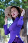 Retrato de una hermosa mujer vestida con un traje tradicional y sombrero cónico, Vietnam - foto de stock