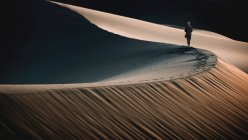 Donna che cammina lungo il crinale di una duna di sabbia nel deserto, Stati slegati — Foto stock