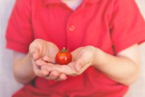 Хлопчик тримає помідор — стокове фото
