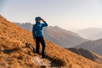 Escursionista in piedi in montagna guardando attraverso il binocolo, Bad Gastein, Salisburgo, Austria — Foto stock
