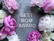 Pfingstrosen auf grauem Hintergrund um die Worte Best Mom Award — Stockfoto