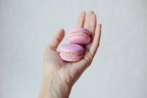 Woman's hand holding two macaroons — Stock Photo