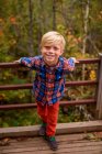 Retrato de um menino sorridente em pé em uma ponte, Estados Unidos — Fotografia de Stock