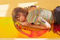 Portrait of a woman lying on holographic foil — Stock Photo