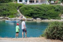 Pai e filho em pé à beira-mar, Menorca, Espanha — Fotografia de Stock