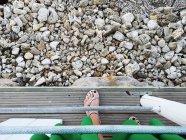 Вид сверху на женскую ногу, стоящую на пирсе, Италия — стоковое фото
