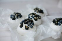 Pavlova-Desserts mit Blaubeeren und Brombeeren auf Pergament — Stockfoto