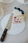 Slice of raspberry and cream cheese cake next to a knife — Stock Photo