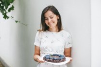 Woman holding a Blueberry chocolate brownie cake — Stock Photo