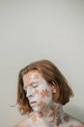 Portrait of young man with white face and body art with flowers — Stock Photo
