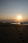 Silhouette di due persone in piedi sulla spiaggia di pesca al tramonto, Bleriot Beach, Pas-de-Calais, Francia — Foto stock