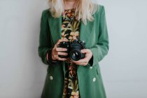 Donna in giacca verde con fotocamera vintage — Foto stock