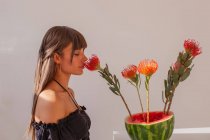 Mujer oliendo una flor de protea - foto de stock