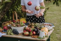 Plan recadré de la femme par table avec des fruits et légumes frais — Photo de stock