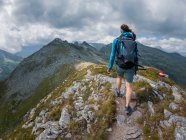 Femme en vêtements de sport randonnée dans un beau paysage montagneux — Photo de stock