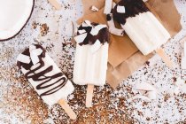 Three coconut yogurt and chocolate popsicles on a table — Stock Photo