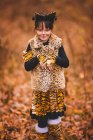 Chica en el bosque vestida de tigre para Halloween, Estados Unidos - foto de stock
