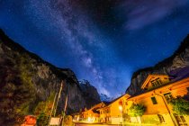 Calle iluminada del pueblo por la noche, Lauterbrunnen Valley, Berna, Suiza - foto de stock