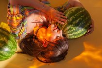 Woman lying on the floor next to two watermelons — Stock Photo