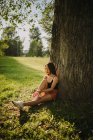 Frau sitzt unter einem Baum im Park, Serbien — Stockfoto