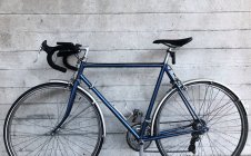 Велосипед прислонился к бетонной стене — стоковое фото
