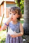 Menina de pé no parque comer pipocas — Fotografia de Stock