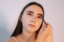 Woman brushing her eyebrows — Stock Photo