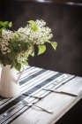 Fiori lilla bianchi su un tavolo da pranzo — Foto stock