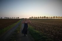 Woman walking along a rural road, Deux-Sevres, Nouvelle Aquitaine, França — Fotografia de Stock