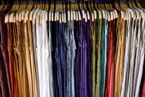 Multi-colored dresses hanging in a wardrobe — Stock Photo