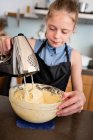 Girl standing in the kitchen baking a cake — Stock Photo