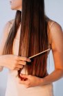 Close-up of a woman combing her long hair — Stock Photo