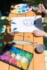 Девушка сидит в саду и рисует акварелью — стоковое фото