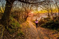 Donna che cammina nel bosco al tramonto, Gabicce Monte, Marche, Italia — Foto stock